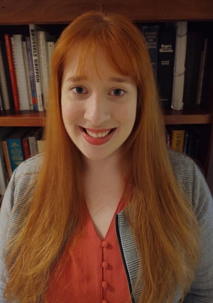 Photo of woman with red hair in front of a bookcase